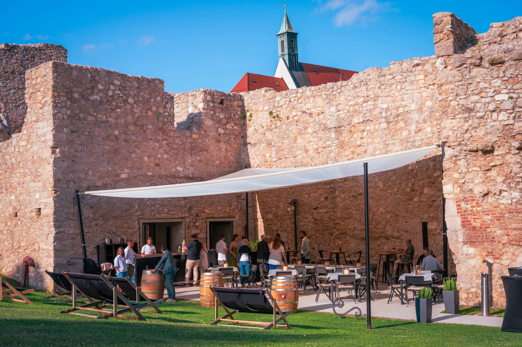 Innenhof der Kasematten mit Sonnensegel und Liegestühlen vor den Ziegelmauern
